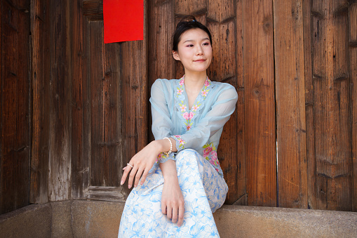Asian woman sitting on the threshold