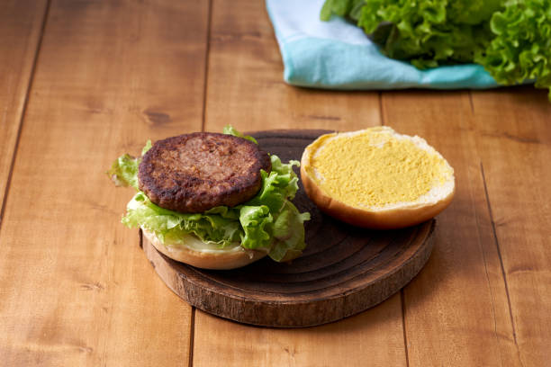 istock Delicious hamburger with green salad on a wooden table. 2124352336