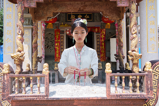 Asian woman praying in temple