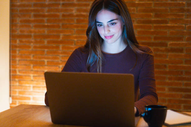 istock Portrait of young happy woman using laptop at night, using modern technology havinmg fun with glowing screen in dark office or at home, startup business meeting online with businesswoman 2124358526