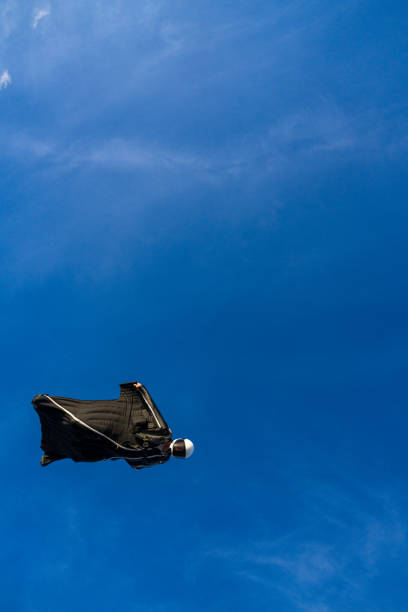 Wing suit flier soars in blue skies
