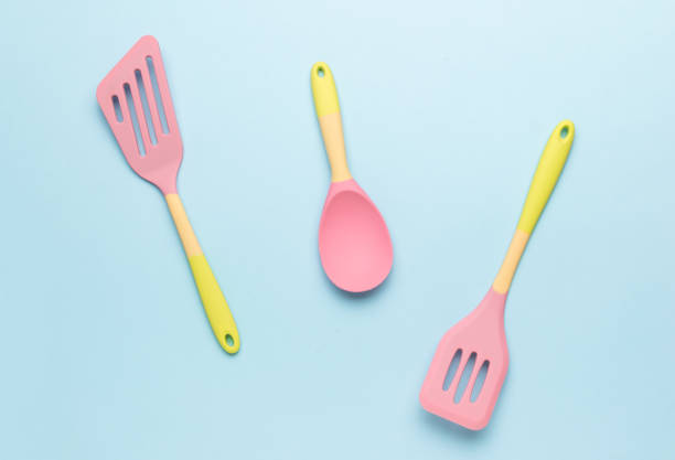 istock Yellow and pink silicone kitchen spatulas on a blue background. 2124426641