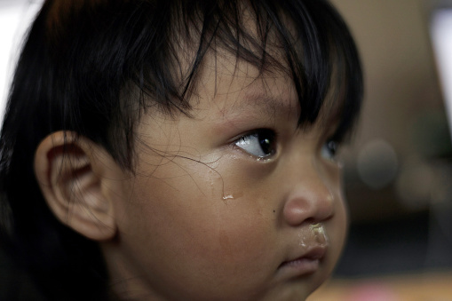 Crying boy with tear on cheek. Kid crying, focus on his tear.