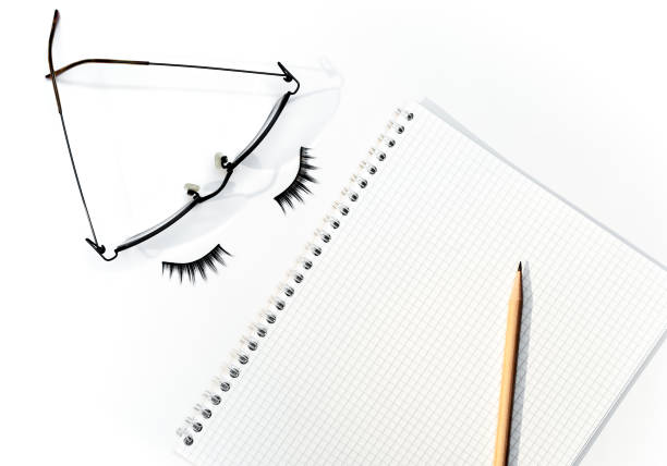 Pencil over open notepad with glasses and eyelashes, business concept.