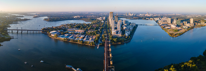 Panoramic aerial drone view of Rhodes and Wentworth Point, showing Homebush Bay and Parramatta River in Sydney, NSW Australia on a sunny morning in March 2024