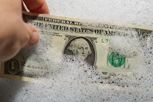 Money laundering. US dollar currency banknotes in soap water