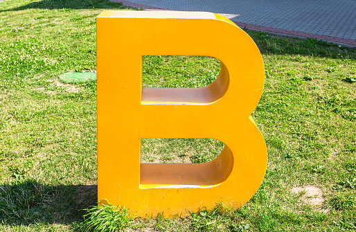 Letter B layout is located on the green grass in summer