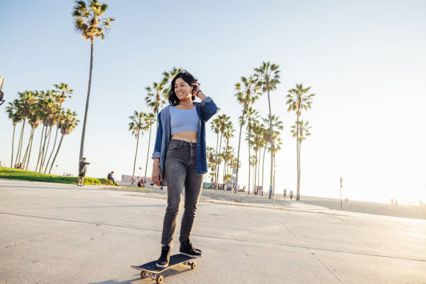 istock Woman skating by the beach at sunset 2124595368