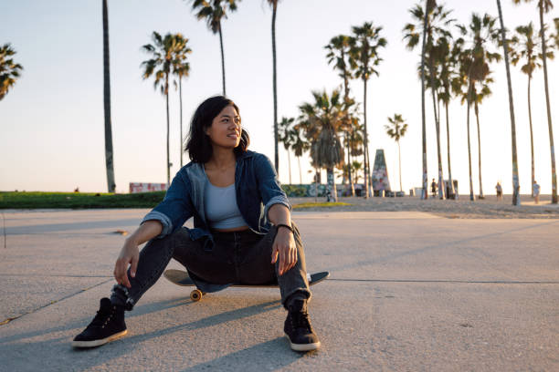istock Young skater sitting on skateboard at the skate park 2124604146