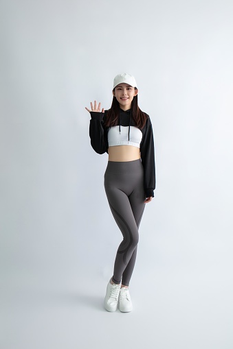 Asian woman in sportswear waving hand