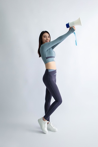 Asian young woman holding megaphone cheering with sportswear