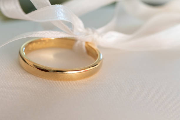 istock golden wedding ring tied with elegant white ribbon 2124624077