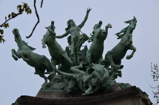 A grayscale shot of a sculpture of a baby boy on the Alexander III Bridge Paris