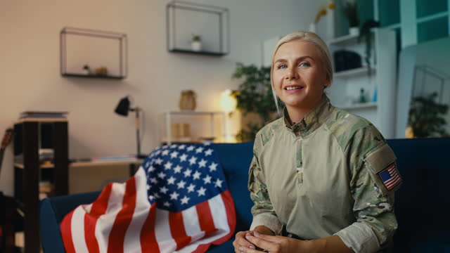 Portrait of a smiling female soldier sitting on a sofa, life of U.S. military