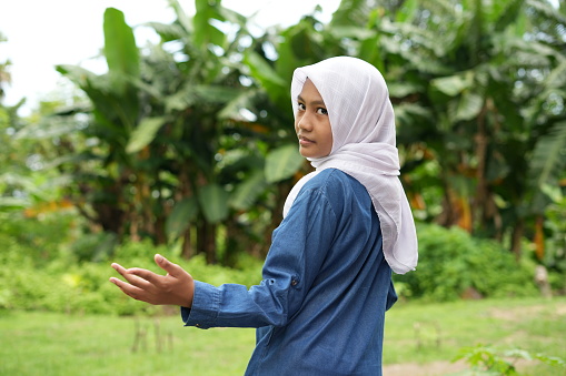 Portrait of Asian girl wearing white hijab standing in park with various expressions