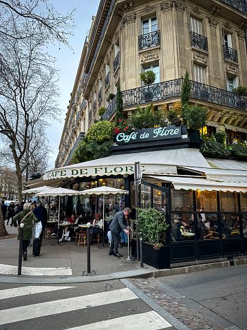 Paris, France - 19.02.2024. Cafe de Flore in Paris, France. The famous Cafe de Flore at the corner of Saint-Germain boulevard and Saint-Benoit street. The place of attraction of the intellectual public. Long-running coffeehouse and celebrity haunt serving familiar French fare in a charming corner locale.