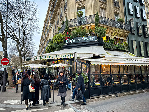 Paris, France - 19.02.2024. Cafe de Flore in Paris, France. The famous Cafe de Flore at the corner of Saint-Germain boulevard and Saint-Benoit street. The place of attraction of the intellectual public. Long-running coffeehouse and celebrity haunt serving familiar French fare in a charming corner locale.