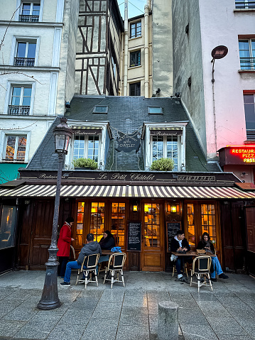 Paris, France - 19.02.2024. Typical French restaurant named Le petit Chatelet near Notre Dame Cathedral in Paris. Located at Square Pierre-Gilles de Gennes at 39 Rue de la Bûcherie. Charming and restaurant in Paris downtown
