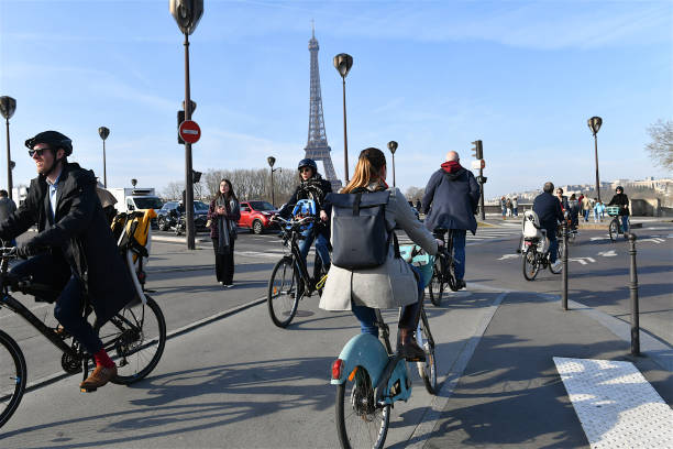 Paris, France-03 22 2024: Cyclists heading to work use a cycle path with the Eiffel Tower in the background, Paris, France.