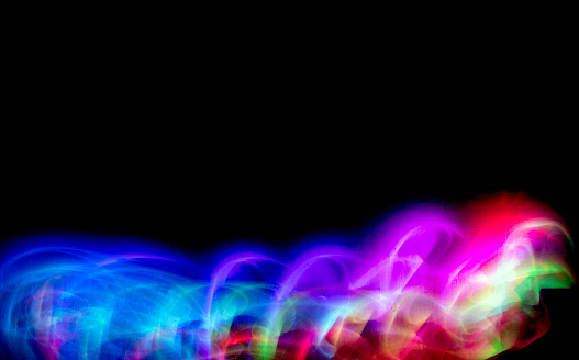 Abstract colorful irregular lines on black background and wall texture. Long exposure. Light painting photography.