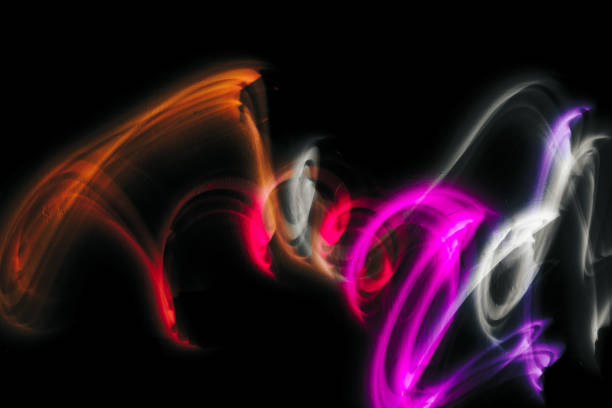 Abstract colorful irregular lines on black background and wall texture. Long exposure. Light painting photography.
