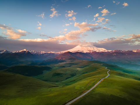 Elbrus mount with clouds at sunrise. Gil-Su valley in North Caucasus, Russia. Aerial view. Beautiful summer landscape