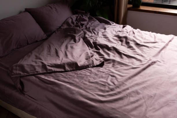 istock morning mess on a crumpled silk bed, lilac color 2124992570