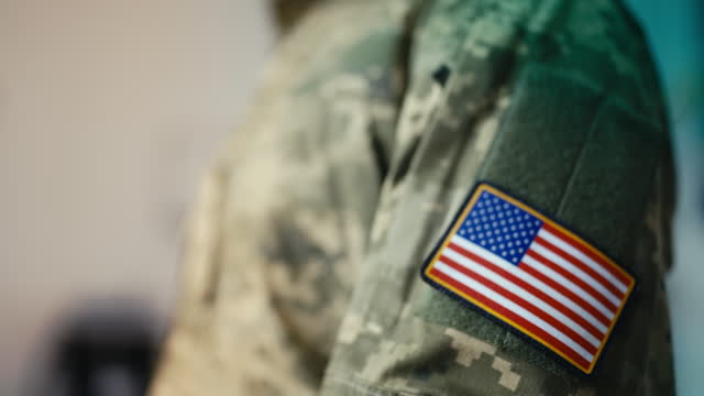 Woman soldier putting on U.S. military patch, getting ready to leave for work
