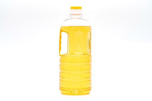 A bottle of yellow salad oil on a white background