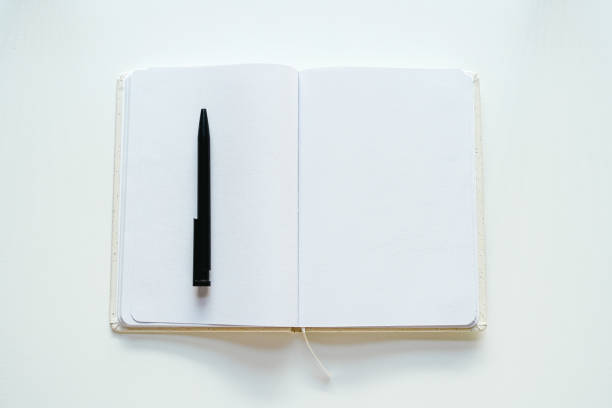 Open recycled paper book (notebook) with blank pages and black pen