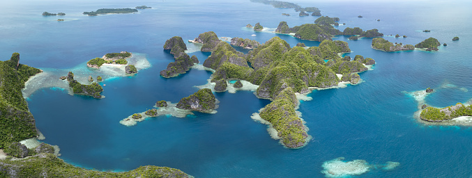 The limestone islands of Balbalol, fringed by reef, rise from Raja Ampat's tropical seascape. This region is known as the heart of the Coral Triangle due to the high marine biodiversity found there.