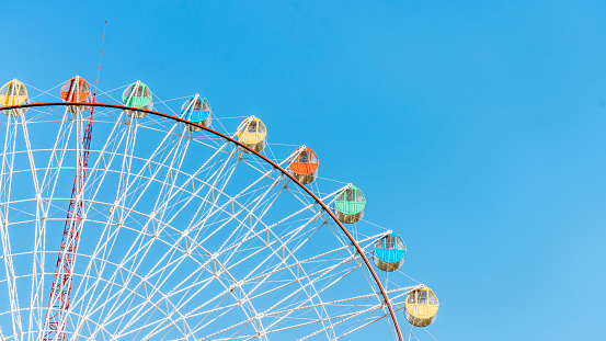 Close up of Ferris wheel under blue sky