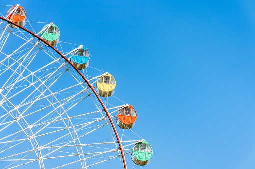 Close up of Ferris wheel under blue sky