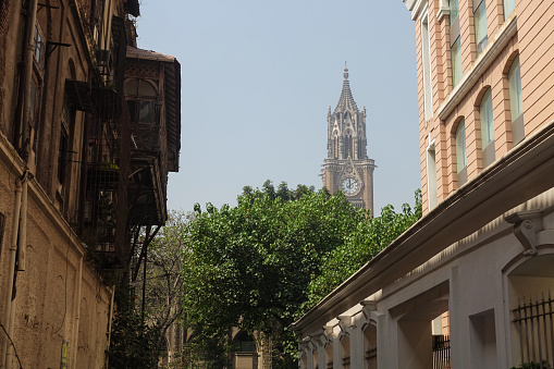 View of the top of the Rajabai Clock Tower from an alley street in Mumbai