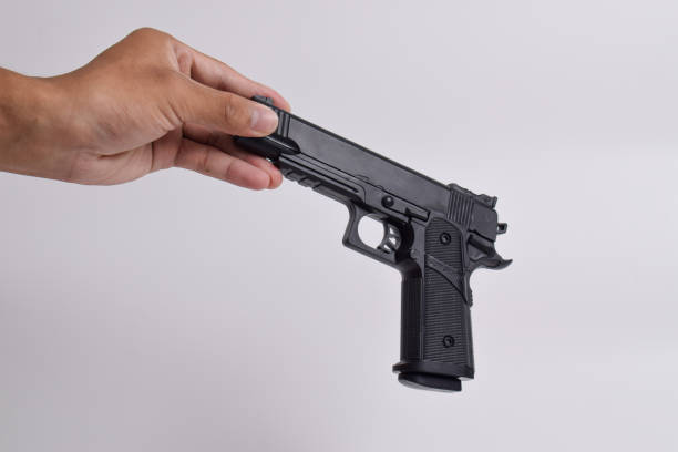 istock Male hand holding a gun on white background 2125122714