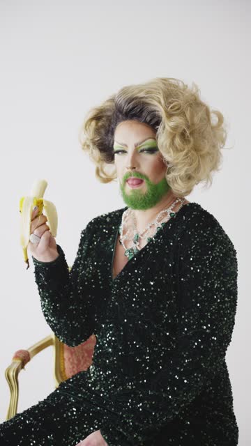 Drag Queen With Green Beard Eating a Banana in a Studio Setting