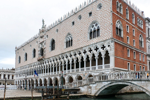 Exterior of Doges Palace, Venetian Gothic style former residence of the Doge of Venice, with Ponte della Paglia bridge besides - Venice, Italy