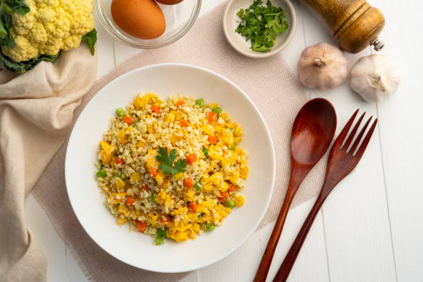 istock Cauliflower fried rice,Stir fried cauliflower rice with eggs ,carrot ,bean and corn in white plate.healthy eating and low calories food. 2125182115