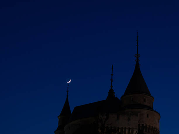 A large building with a steeple and a crescent moon in the sky