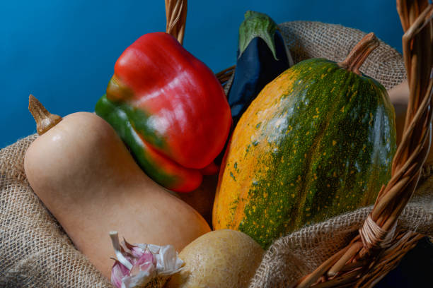 Basket with potatoes, pumpkins, peppers, eggplant and garlic