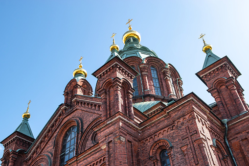 Travel image of Uspenski Cathedral against blue sky in Helsinki, Finland. The largest Greek Orthodox church in Western Europe. Low angle view.