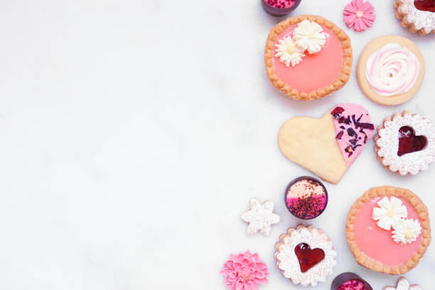 istock Mothers Day or love themed baking side border with various cookies and sweets on a white marble banner background 2125398211