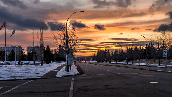Sunset landscape in city of Edmonton with light snow cover and red traffic lights