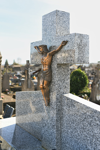 Crucified Jesus Christ on a cross on a grave in a European cemetery