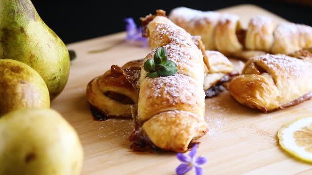 Sweet pastries, puff pastries with pears, on a wooden table
