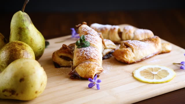 Sweet pastries, puff pastries with pears, on a wooden table