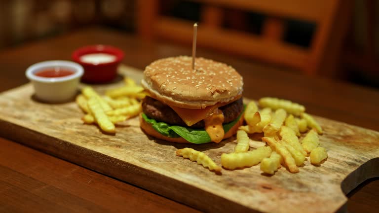 Cheeseburger With French Fries On The Table In A Pub