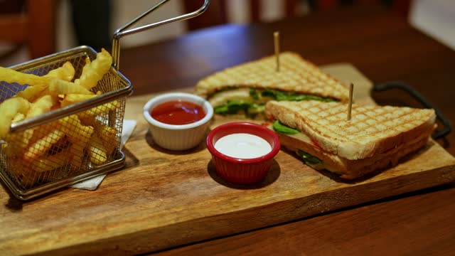 Club Sandwich With French Fries And Dipping Sauces On The Table In A Pub