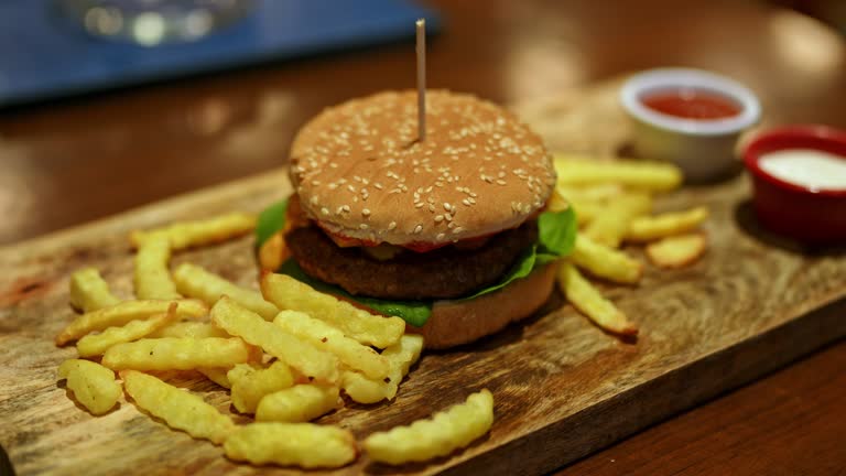 Cheeseburger With French Fries On The Table In A Pub