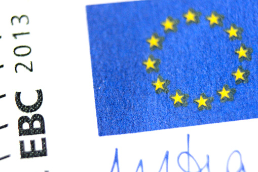 Fragment of a five euro banknote close-up with the flag of the European Union.